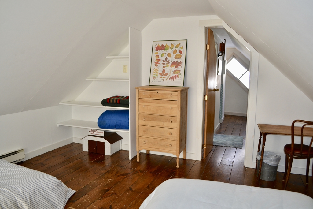 Dresser, shelves and view of hallway